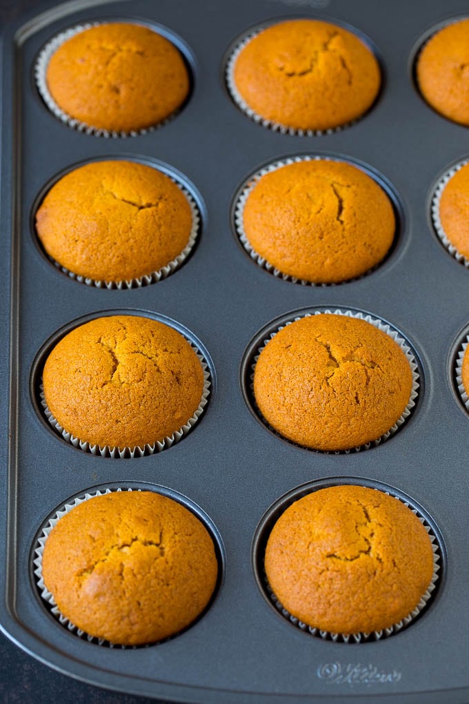 Pumpkin Cupcakes Recipe | Pumpkin Cake #cake #cupcakes #pumpkin #frosting #baking #fall #thanksgiving #bajap Baked cupcakes in a muffin tin.