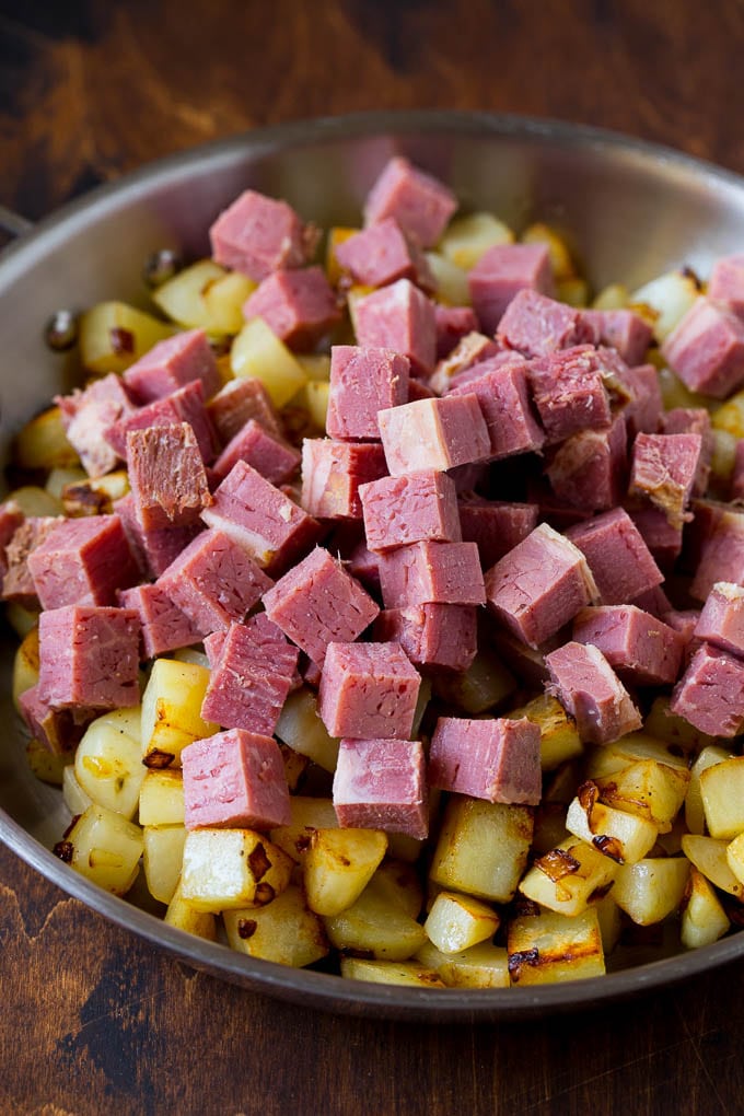 Corned Beef Hash Recipe #hash #cornedbeef #stpatricksday #breakfast #brunch #potatoes #bajap Cubed corn beef on top of cooked potatoes.
