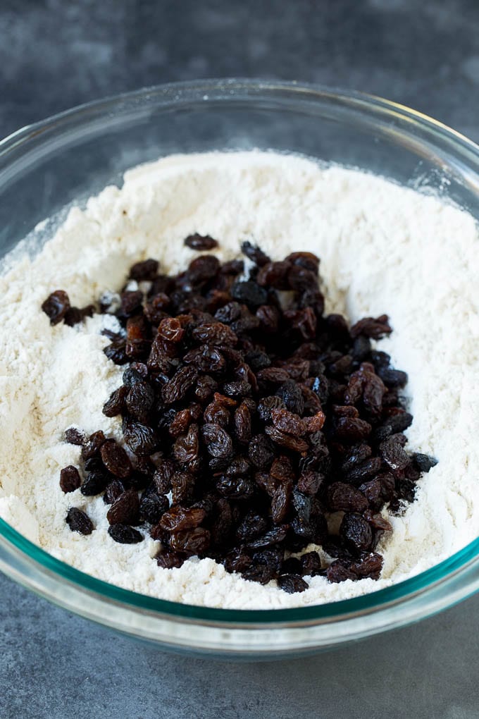 Irish Soda Bread Recipe #bread #baking #stpatricksday #sidedish #bajap Flour, sugar, butter, baking powder and raisins in a mixing bowl.