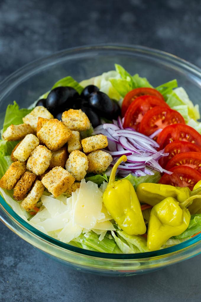 Olive Garden Salad Recipe | Italian Salad #salad #lettuce #olives #sidedish #dinner #bajap Lettuce, vegetables, olives and croutons in a bowl.