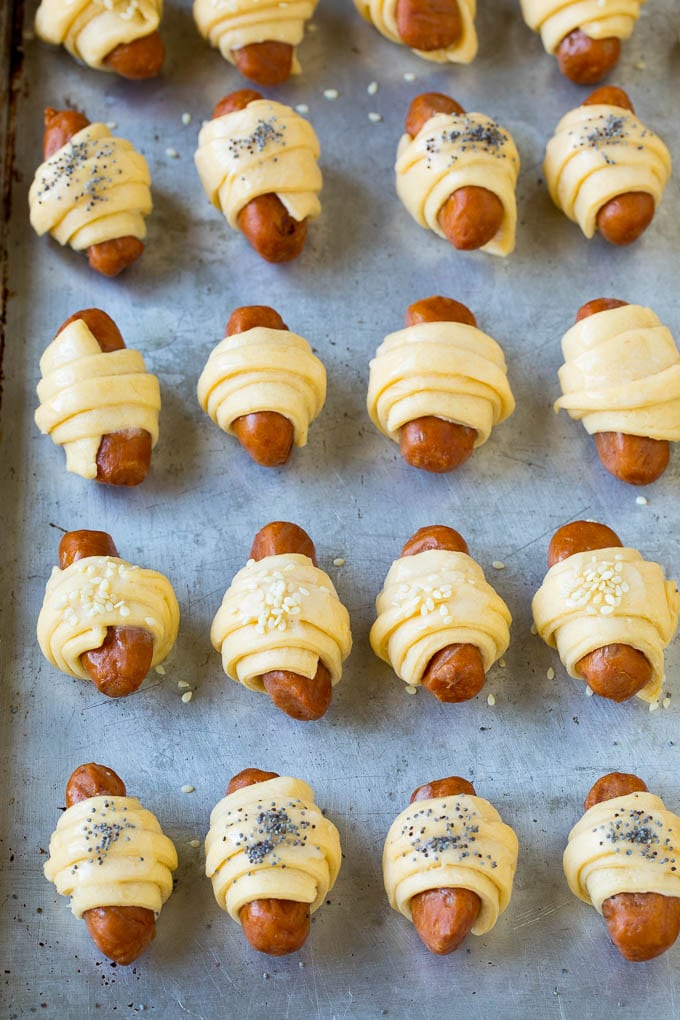 Pigs in a Blanket Recipe #hotdogs #appetizer #snack #comfortfood #bajap Mini hot dogs wrapped in crescent dough and topped with seeds.