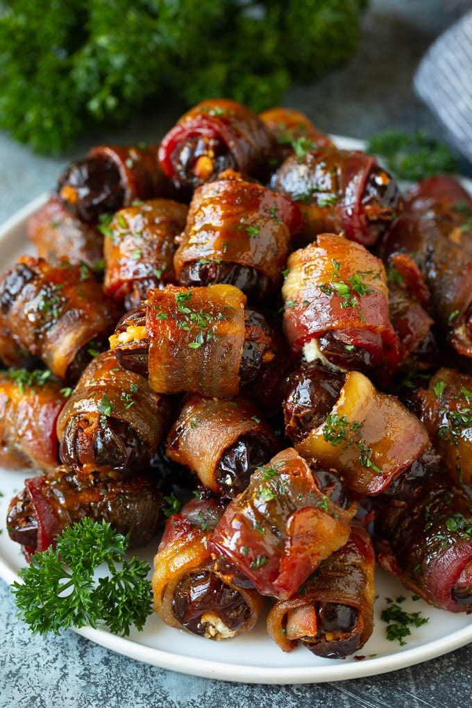Bacon Wrapped Dates #appetizer #bacon #dates #cheese #bajap A plate of bacon wrapped dates stuffed with goat cheese.