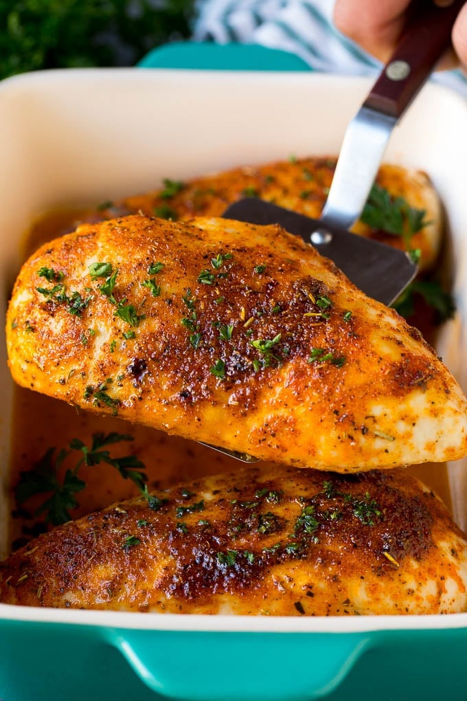 Baked Chicken Breast Recipe #chicken #dinner #bajap A spatula serving up a portion of roasted chicken breast.