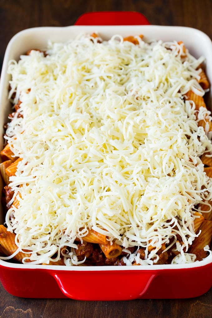 Baked Rigatoni Pasta #pasta #dinner #italianfood #groundbeef #bajap #casserole A pan of pasta in sauce topped with shredded cheese.