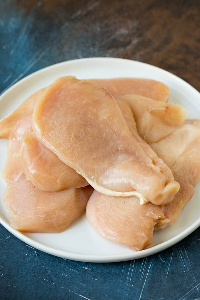 Chicken Francese Recipe #chicken #lemon #dinner #bajap Thin cut chicken breasts on a plate.