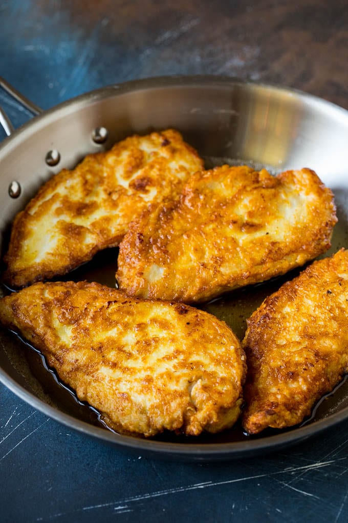 Chicken Francese Recipe #chicken #lemon #dinner #bajap Battered and pan fried chicken cutlets in a pan.