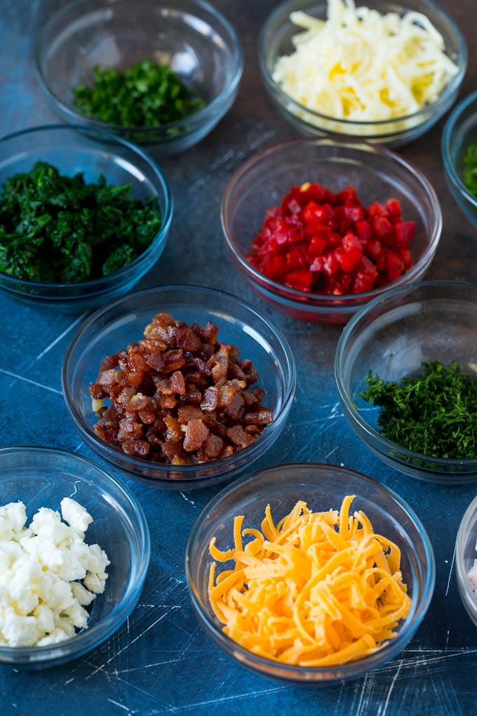 Mini Quiche Recipe #eggs #breakfast #brunch #appetizer #bajap Bowls of assorted flavorings for quiche.