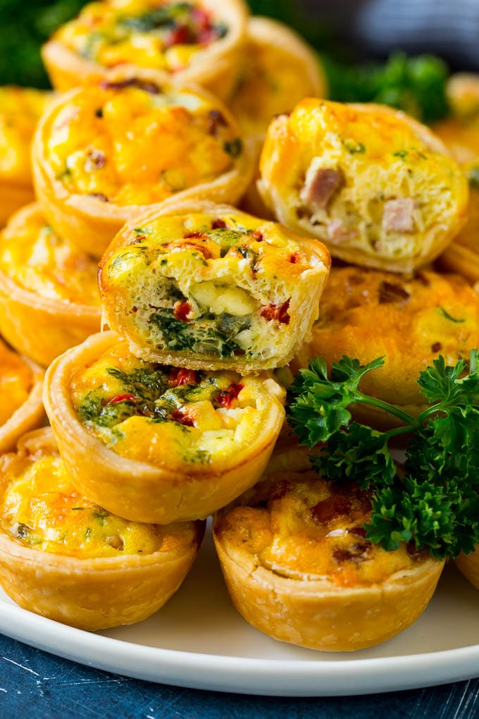 Mini Quiche Recipe #eggs #breakfast #brunch #appetizer #bajap A serving platter of mini quiche with some cut in half.