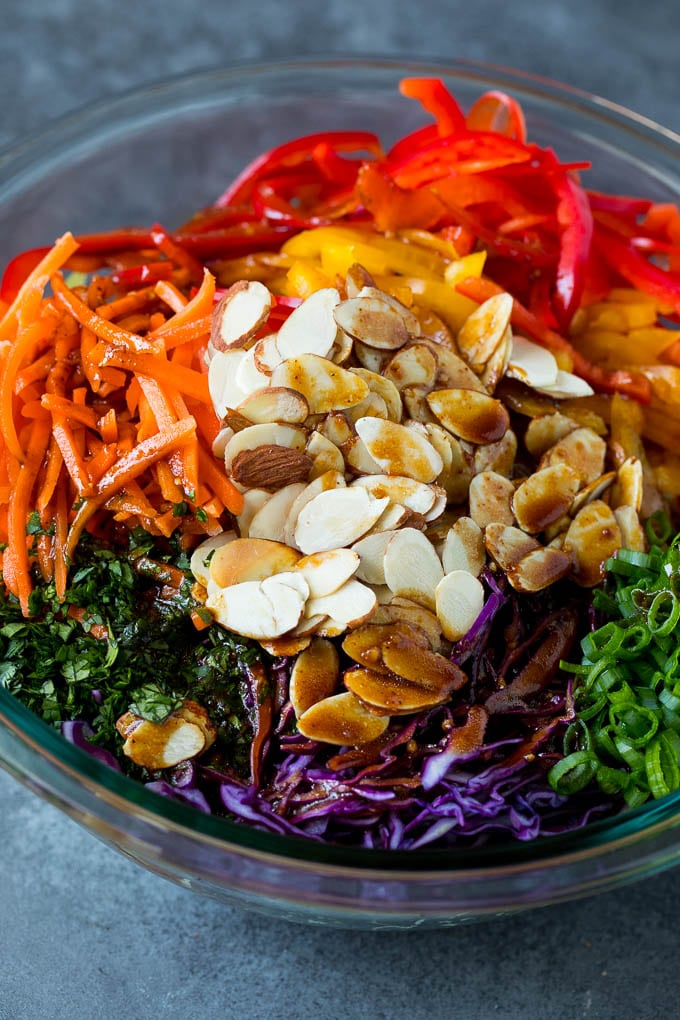 Asian Slaw Recipe #salad #slaw #sidedish #bajap Homemade dressing poured over Asian coleslaw.