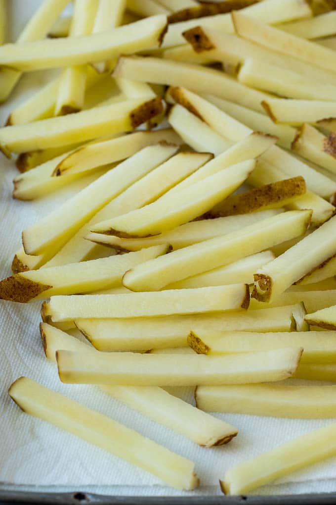 Homemade French Fries Recipe #potatoes #fries #dinner #bajap Potatoes cut into fry shapes on a paper towel lined pan.