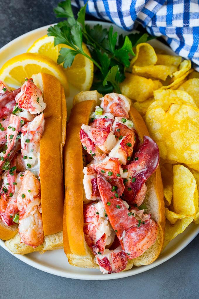 Lobster rolls stuffed with creamy lobster salad in a toasted bun. #lobster #bajap A lobster roll filled with a creamy seafood mixture and served with chips.