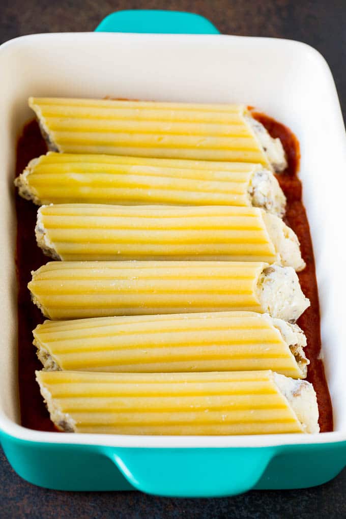 Baked Manicotti Recipe #pasta #cheese #dinner #bajap Pasta tubes stuffed with sausage and cheese in a baking dish.