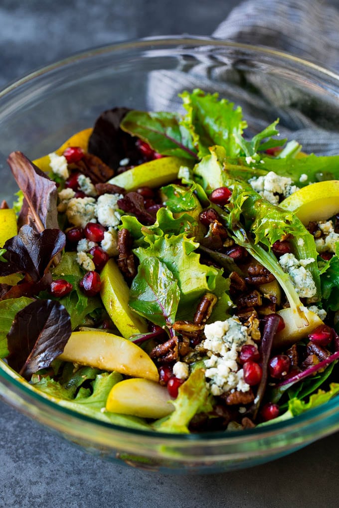 Pear Salad Recipe #salad #pears #fall #winter #dinner #bajap A bowl of pear salad with pomegranate, blue cheese and candied pecans.