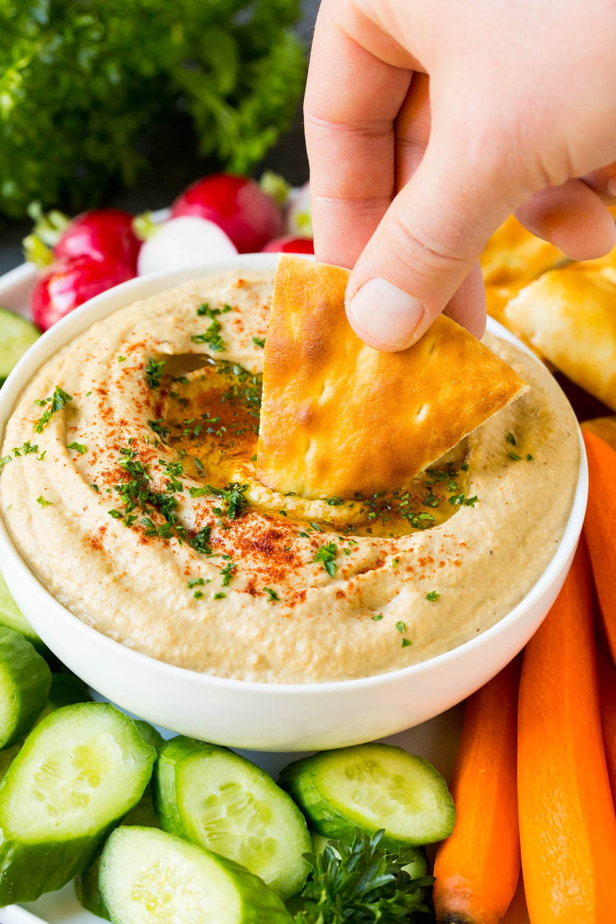 Baba Ganoush Recipe | Eggplant Dip #eggplant #appetizer #dip #healthy #glutenfree #lowcarb #bajap A hand dipping pita bread into baba ganoush.