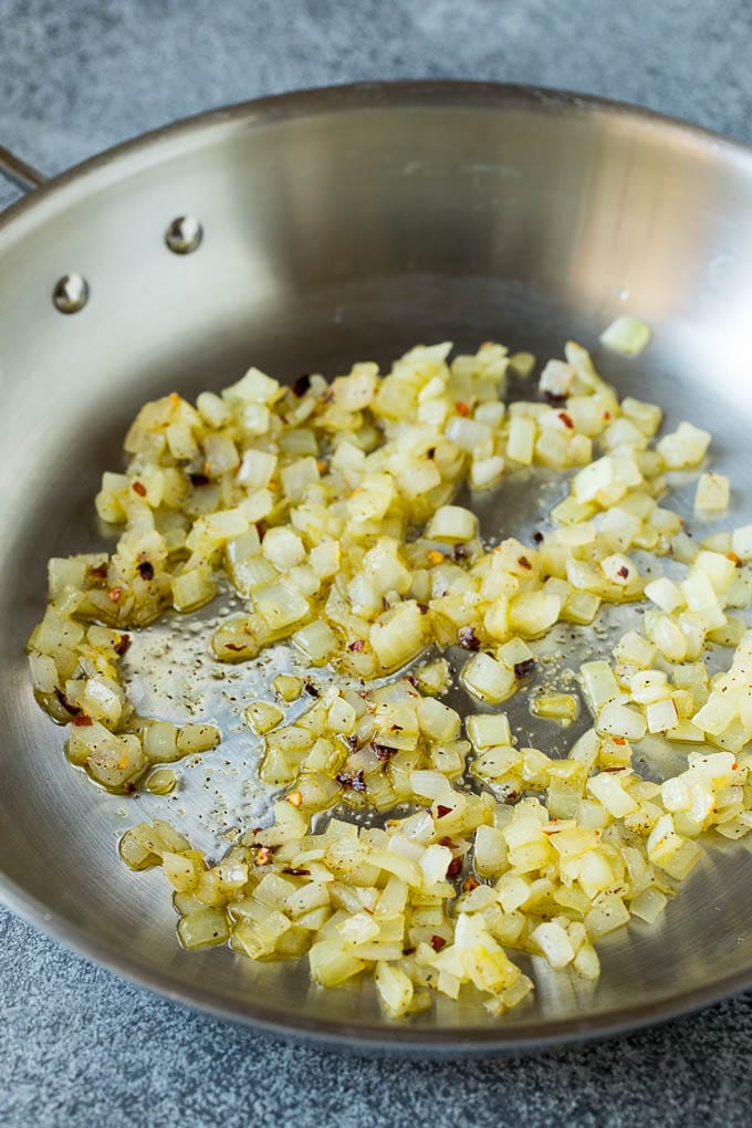 Sauteed kale flavored with olive oil and garlic, a quick and easy side dish! #kale #bajap Sauteed onions in a skillet.
