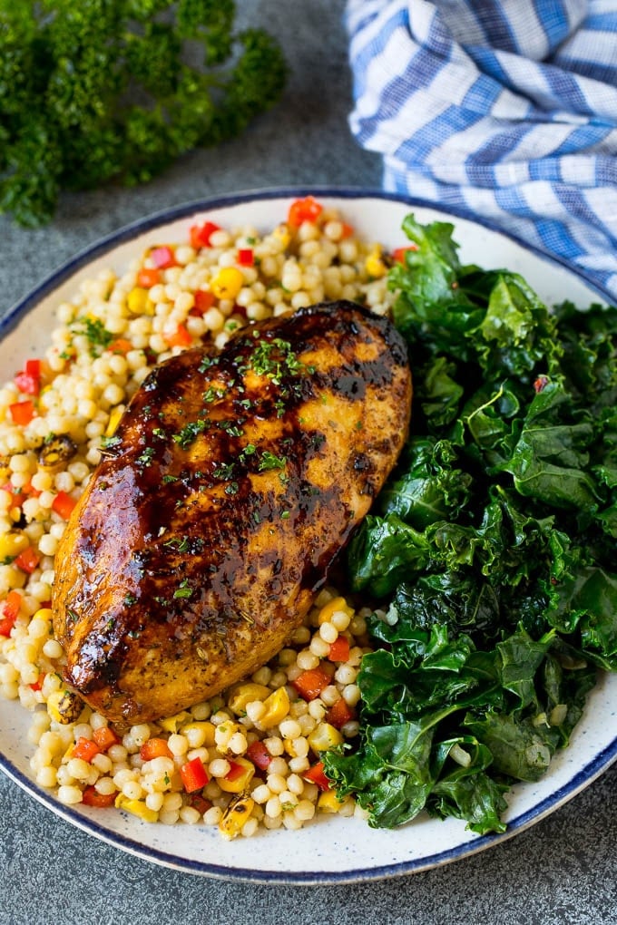 Sauteed kale flavored with olive oil and garlic, a quick and easy side dish! #kale #bajap Grilled chicken served with a side of sauteed kale.