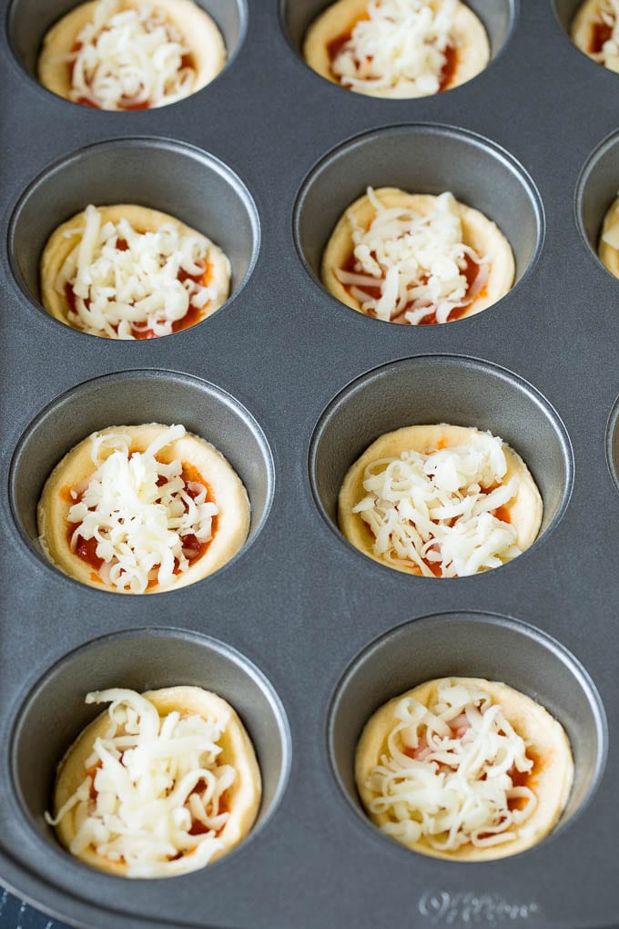Mini pizzas topped with pepperoni are a fun and easy appetizer option. #pizza #bajap #appetizer Circles of dough topped with pizza sauce and shredded cheese.