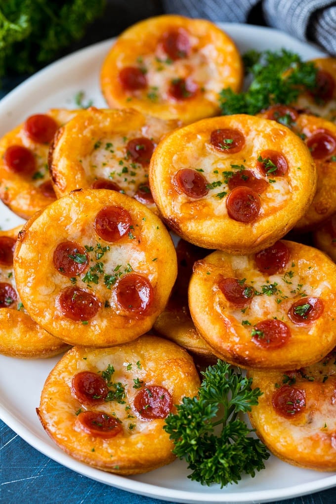 Mini pizzas topped with pepperoni are a fun and easy appetizer option. #pizza #bajap #appetizer Mini pizzas topped with melted cheese and pepperoni.