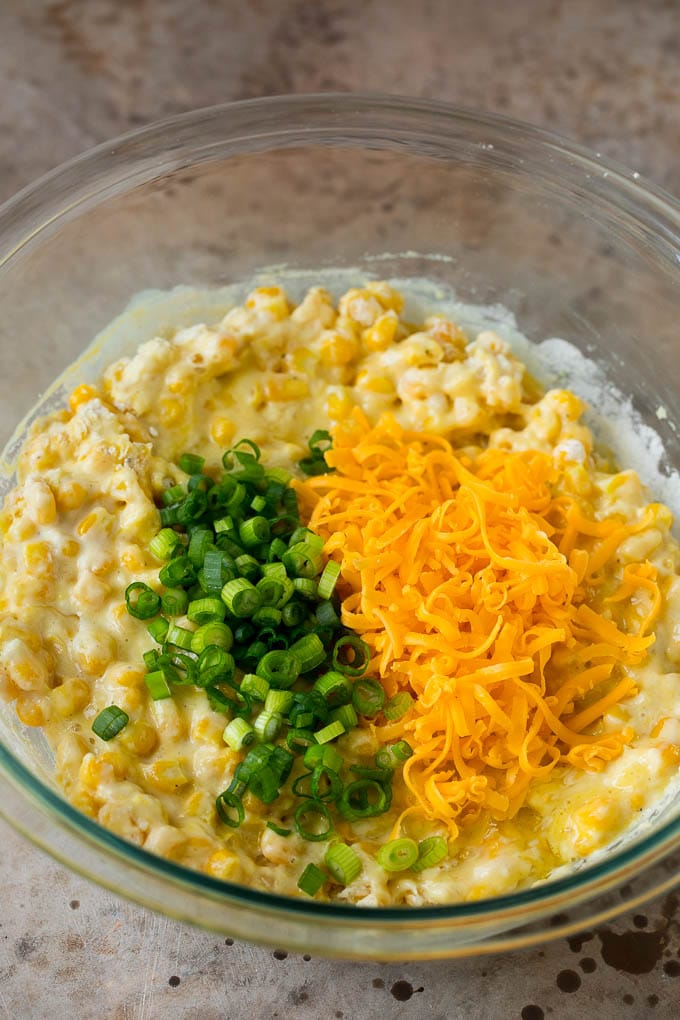 These crispy corn fritters are easy to make and are the perfect appetizer or lighter main course. #corn #bajap Corn batter topped with green onions and shredded cheese.