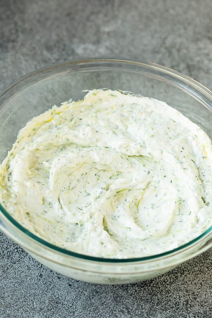 The best homemade tzatziki sauce with cucumber and herbs mixed into Greek yogurt. #appetizer #bajap Tzatziki sauce in a glass bowl.