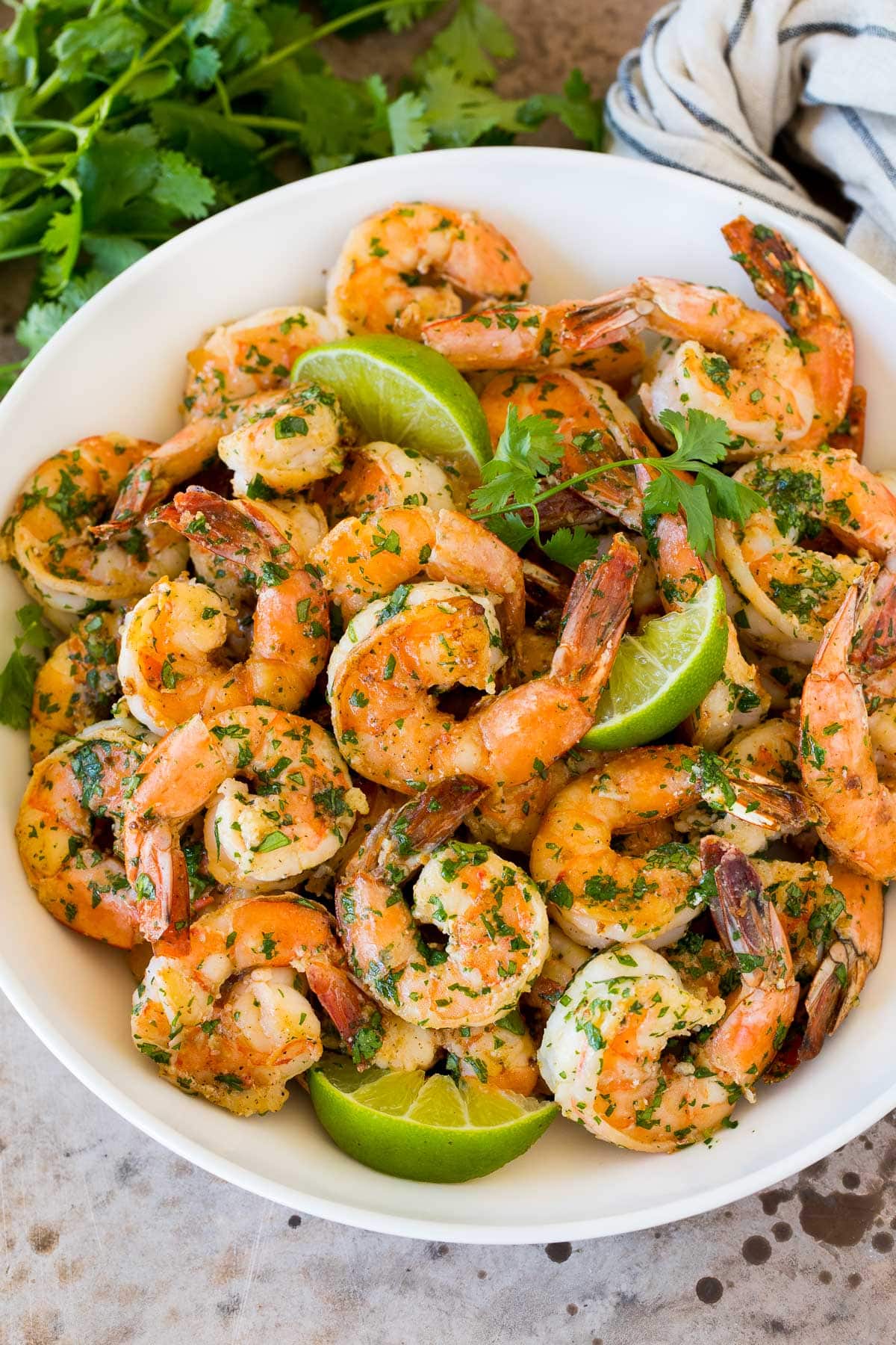 Cilantro Lime Shrimp | Seared Shrimp | Mango Salsa #salsa #shrimp #dinner #appetizer #bajap A serving bowl of cilantro lime shrimp with lime wedges in it.