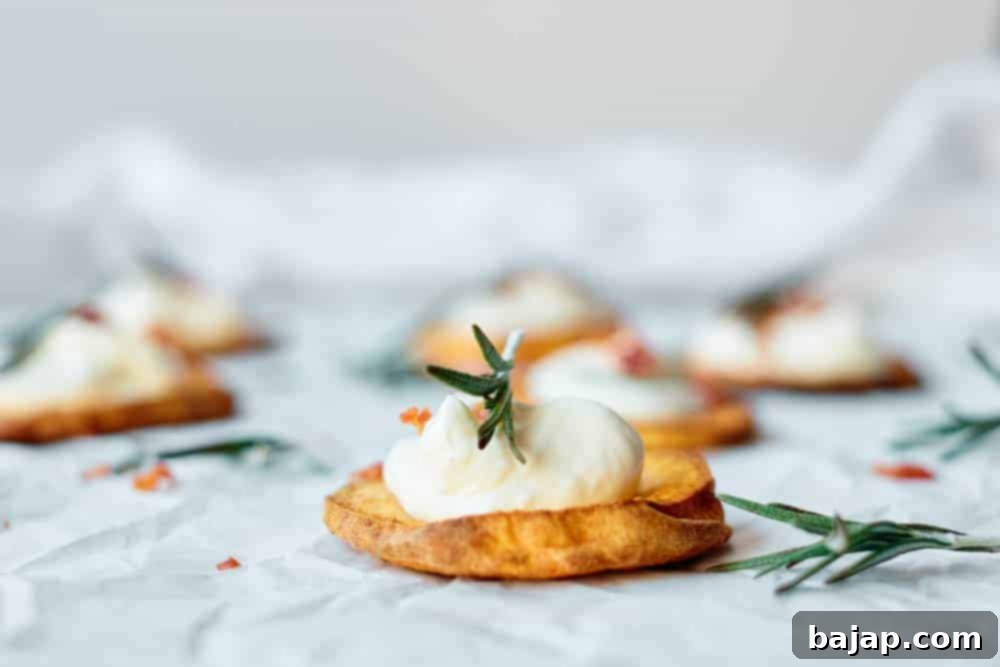 These Sweet Potato Rounds are easy to make with just a few ingredients including: sweet potatoes, olive oil, bacon bits, plain greek yogurt and fresh rosemary. They are a simple, yet elegant appetizer perfect for a party. The sweet potato chips can also be served alongside burgers or just about any main dish.