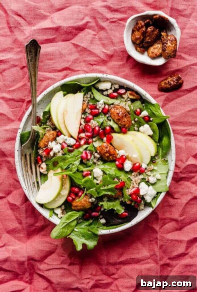 If you're looking for a festive Christmas appetizer salad then this pomegranate salad is for you! Packed with pomegranate seeds, candied pecans, Gorgonzola cheese, apples, cooked quinoa, and a delicious pomegranate salad dressing, this salad is healthy, festive, and oh-so tasty!