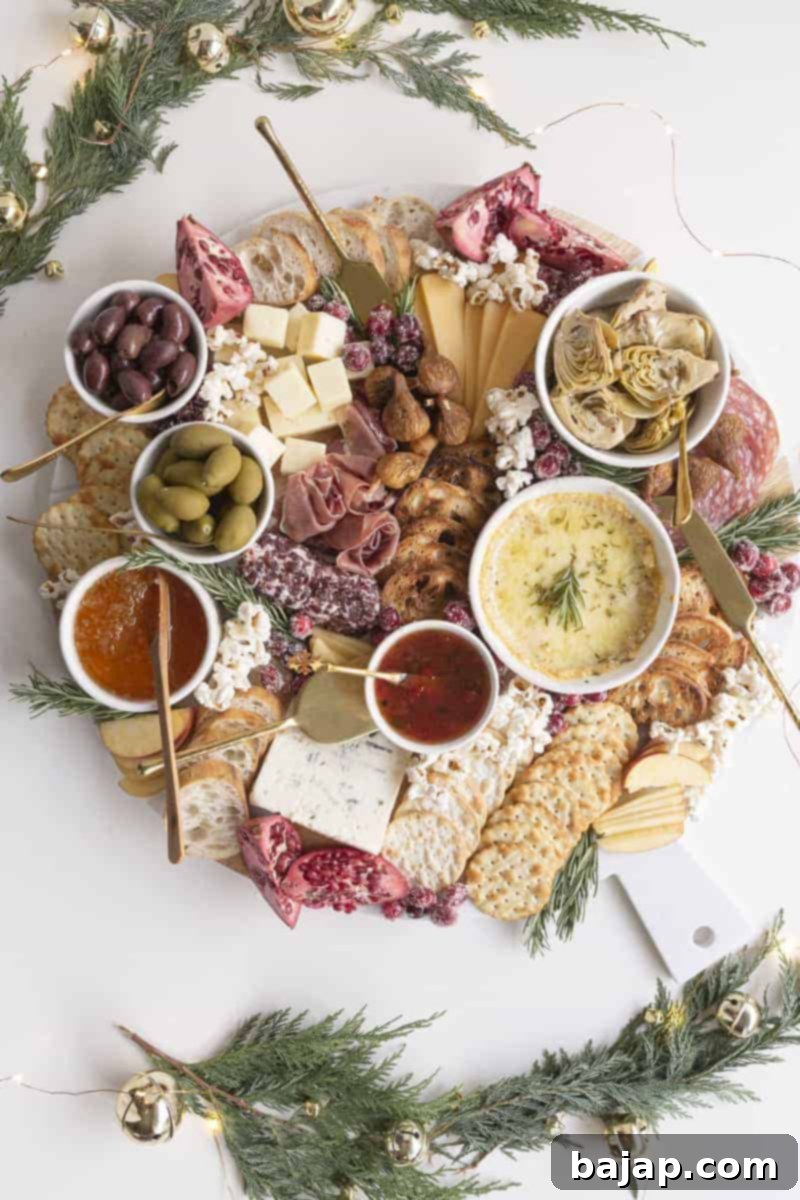 A delicious board filled with cheeses, charcuterie, fruits, and snacks. The perfect appetizer platter to put out at your next gathering!