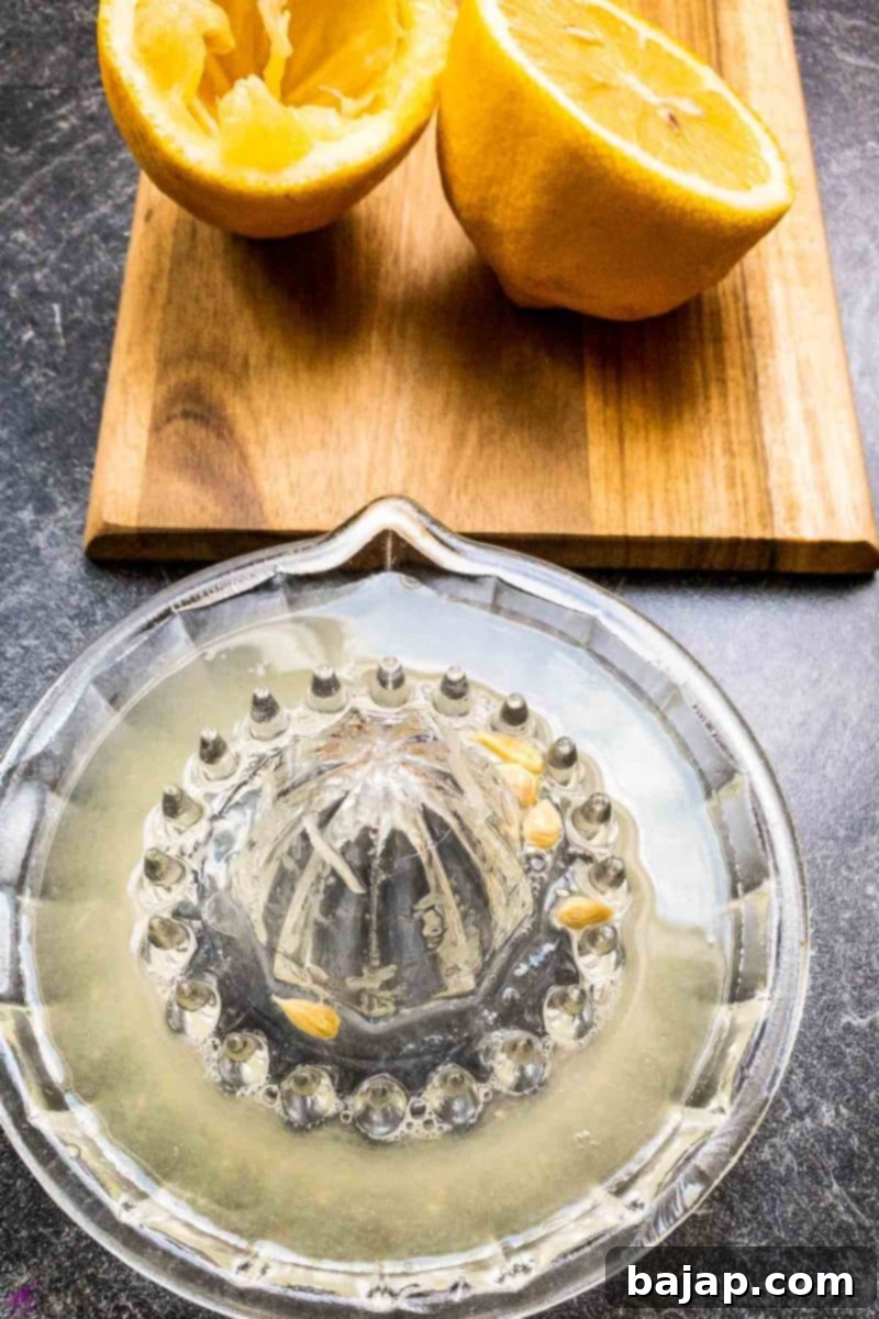 A cocktail glass being rimmed with brown cane sugar for a festive Snowball Cocktail.