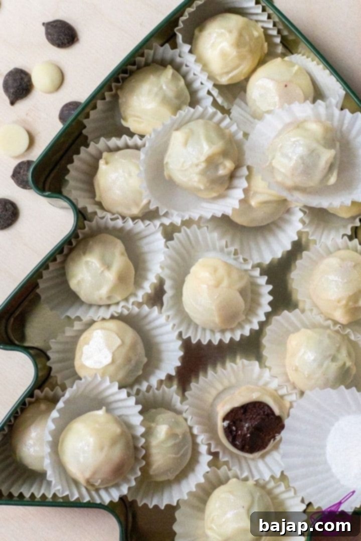 Arranged homemade dark chocolate truffles with white chocolate coating on a serving plate