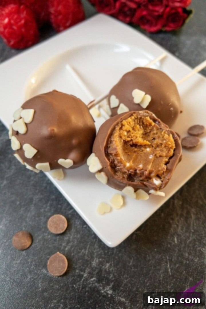 Irresistible no-bake Lotus Biscoff cake pops ready to devour, coated in chocolate and decorated with heart sprinkles.