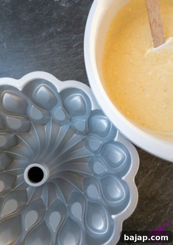 Filling the prepared bundt pan with the fluffy cake dough.