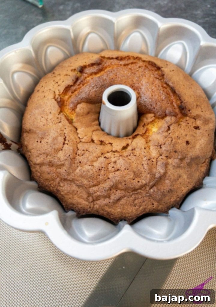 Allowing the whipping cream bundt cake to cool on a rack before unmolding.