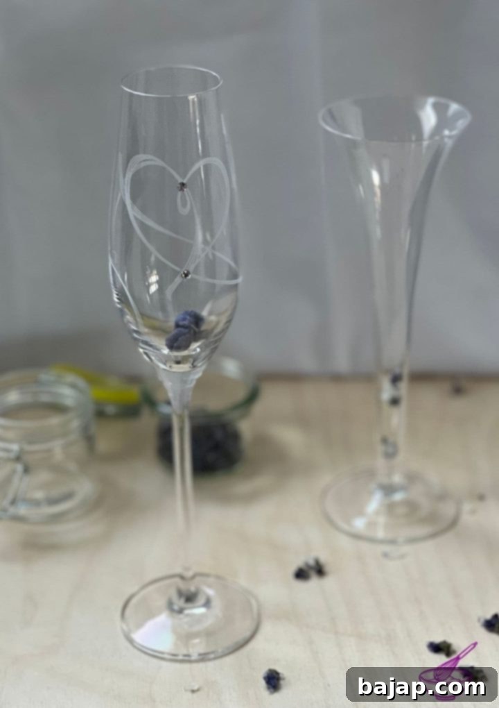 Close-up of sparkling wine being poured over a candied violet in a glass, showcasing the gentle infusion.