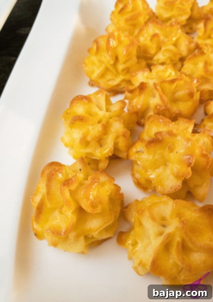 Beautifully piped golden-brown Duchess Potatoes on a baking sheet, ready to be served as a festive side dish.