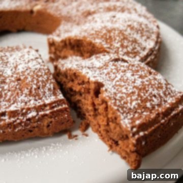 A beautifully sliced chocolate cake, made with egg whites, adorned with powdered sugar and ready for enjoyment.