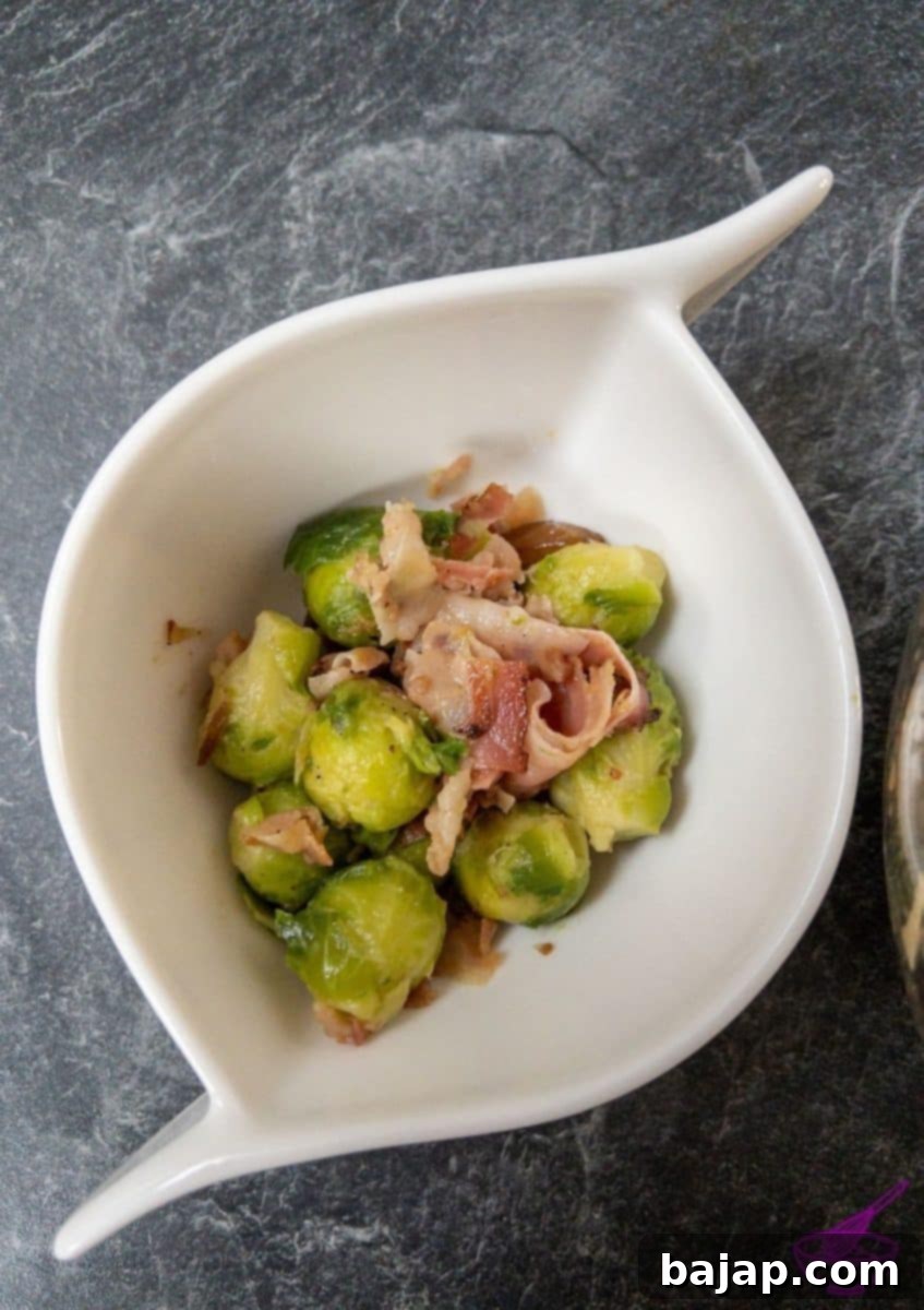 A beautifully arranged bowl of Brussels sprouts with crispy bacon and glistening chestnuts, ready to be served at a holiday feast.