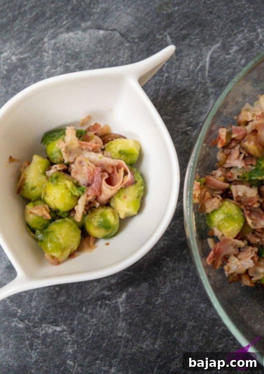 A serving bowl filled with Brussels sprouts, bacon, and chestnuts, garnished and ready for a festive meal.
