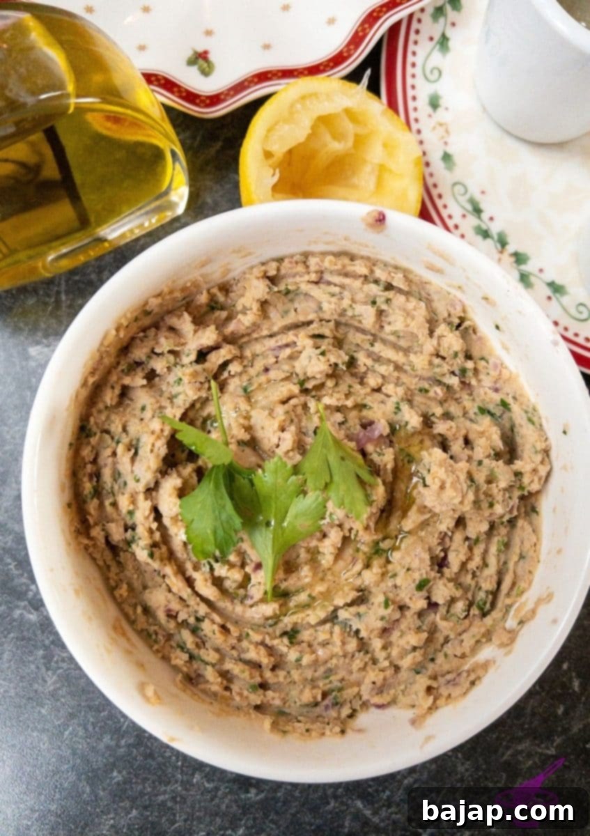 A beautifully garnished bowl of homemade hummus, ready to be served.