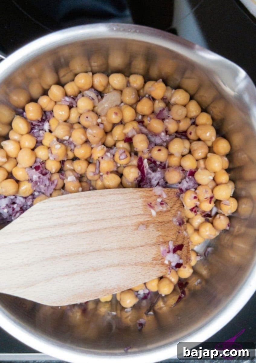 Ingredients being sautéed in a pan, a step in making homemade hummus.