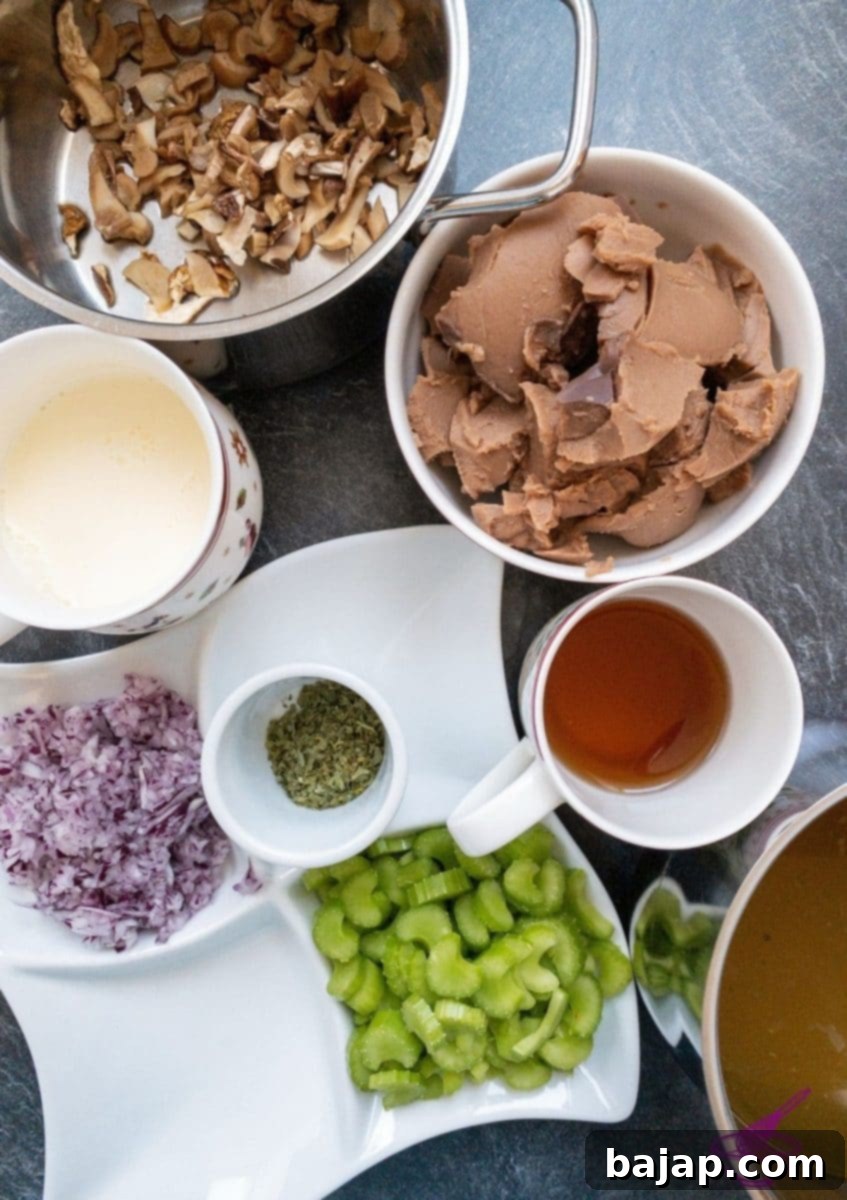 Fresh ingredients laid out for chestnut and porcini mushroom soup, including onions, celery, herbs, chestnuts, and dried porcini mushrooms.