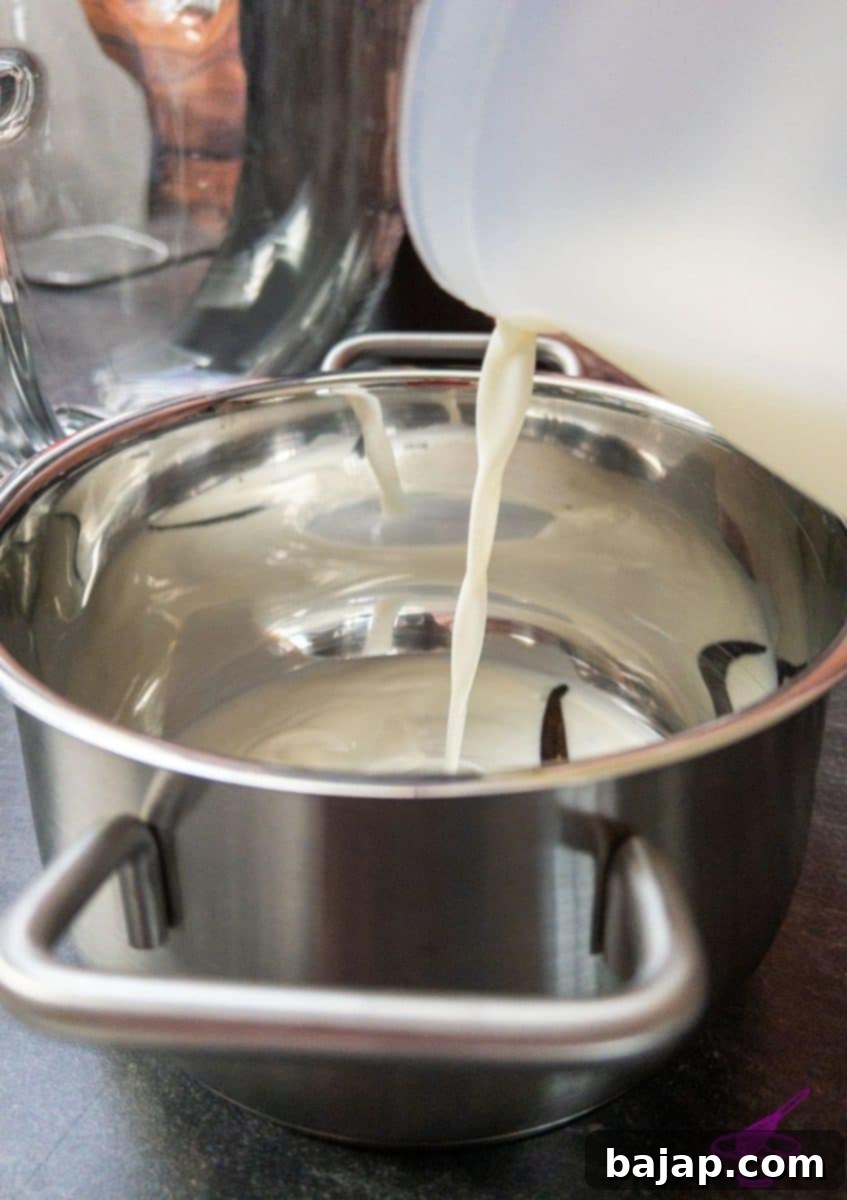 Vanilla bean seeds and pod steeping in milk in a small saucepan.