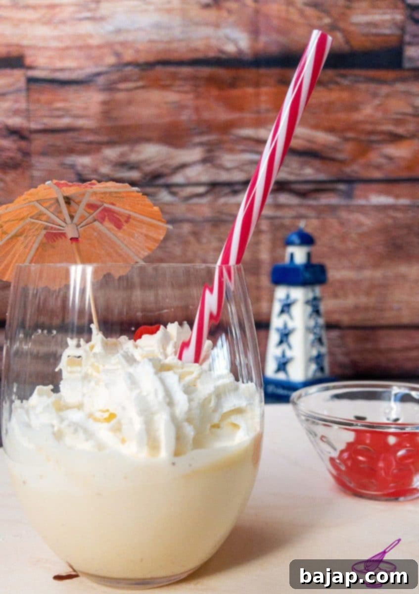Spiked Eggnog Milkshake 2 A refreshing boozy eggnog milkshake, topped with whipped cream and a cocktail cherry, ready to be enjoyed.
