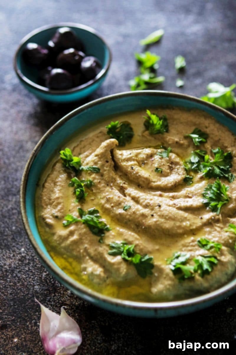 Baba Ganoush Eggplant Dip in a bowl, garnished with parsley.