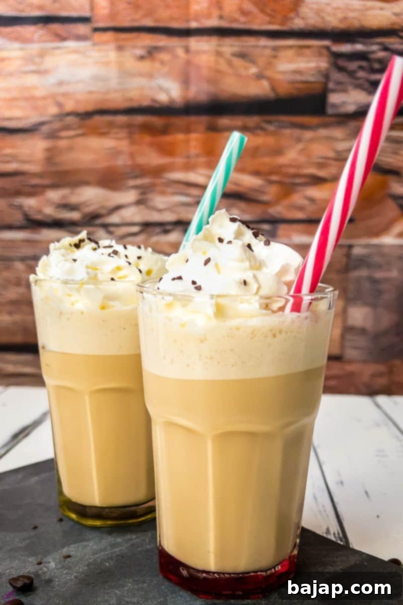 Two glasses of creamy Viennese iced coffee garnished with whipped cream, ready to be enjoyed.
