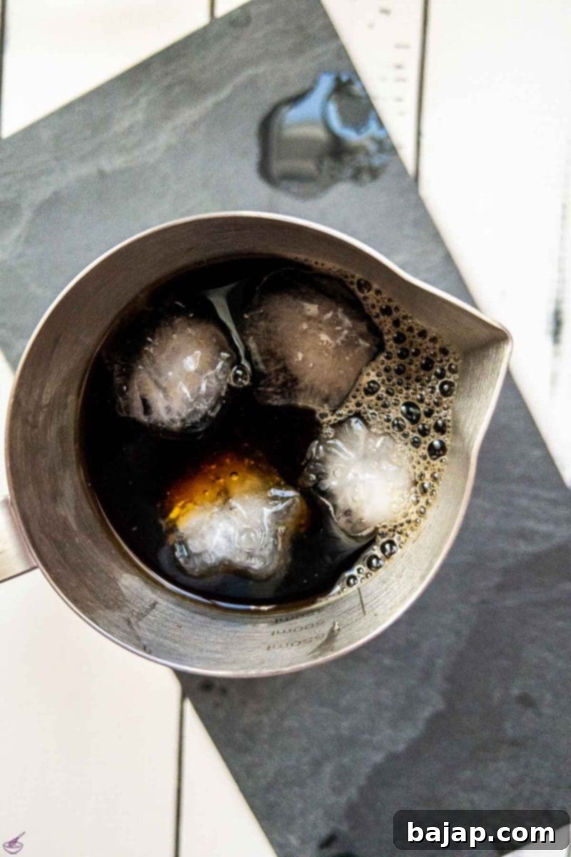 Extend the brewed espresso with ice-cold water in a metal pot.
