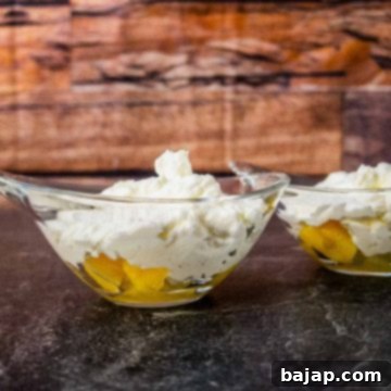 Glass serving bowl with pineapple, whipped cream, and chocolate sprinkles.