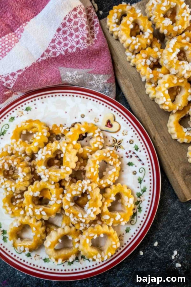 Golden-brown Sour Cream Cookies, delicately brushed with egg yolk and generously sprinkled with pearl sugar, ready to be enjoyed.