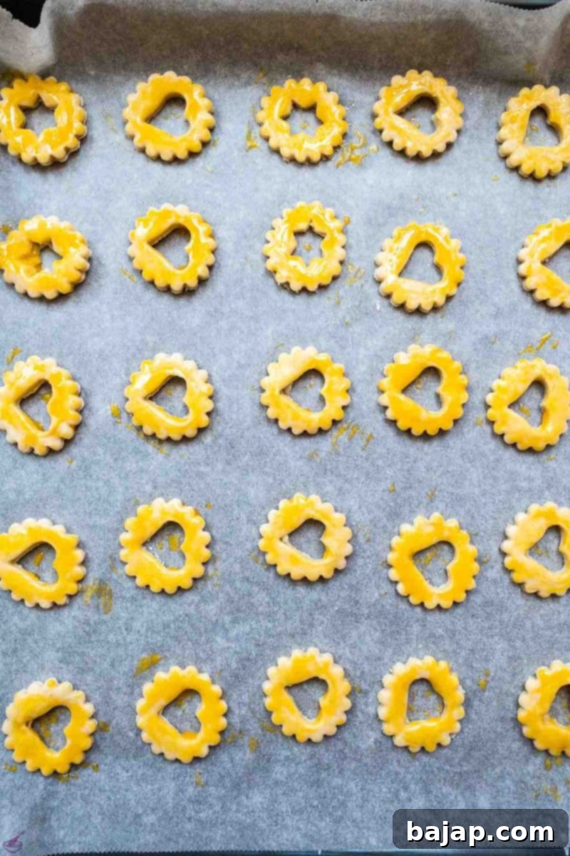 Cut out sour cream cookies before baking. Spread with egg yolk. 