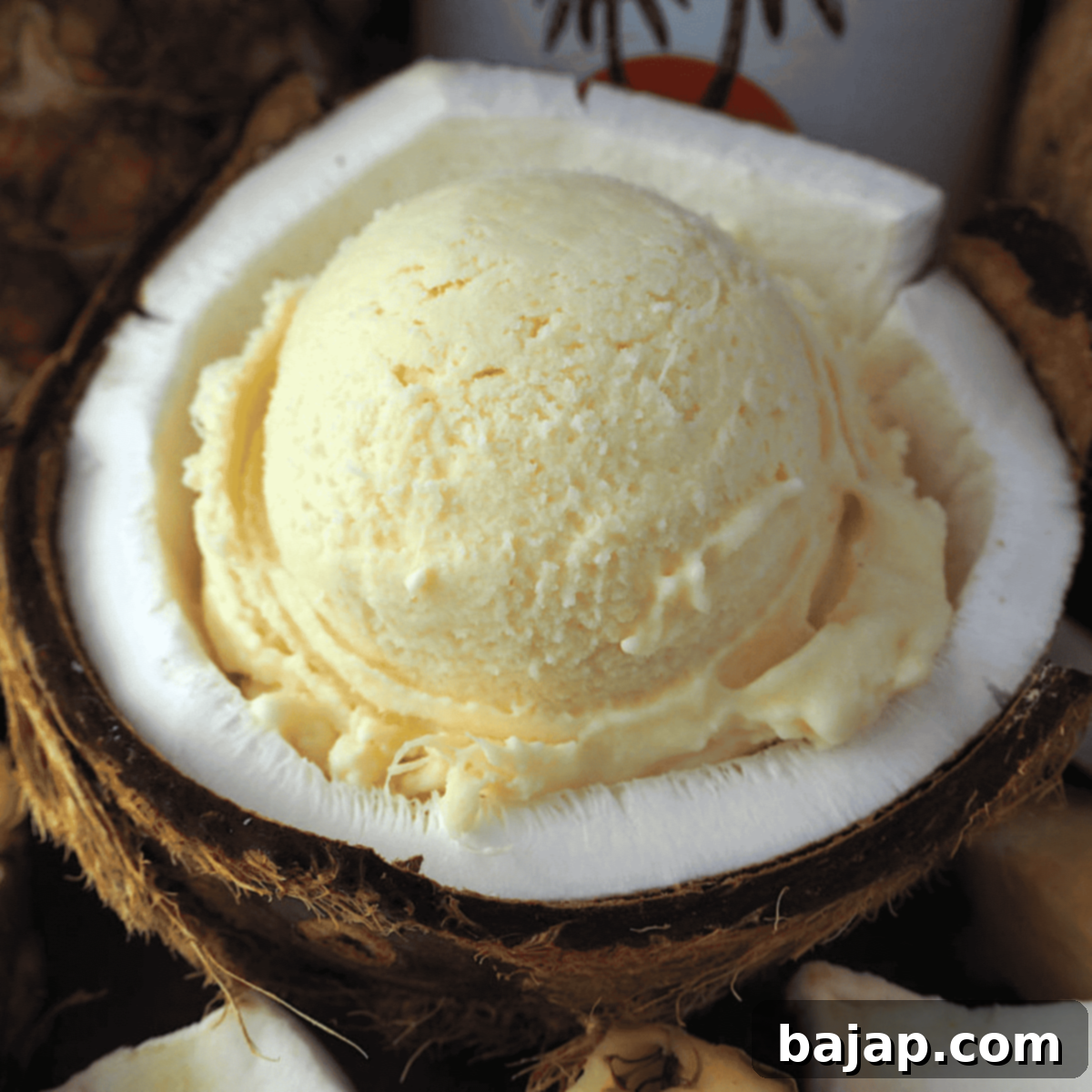 Pina Colada ice cream in a bowl with a spoon and garnished with a cocktail umbrella.